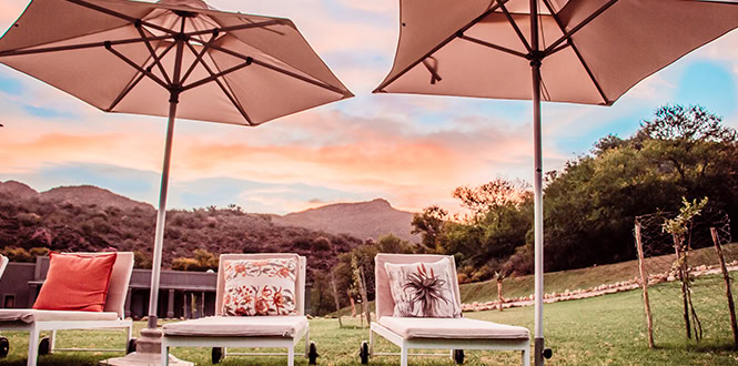 Outdoor seating under umbrellas with mountain views at Wildekloof accommodation